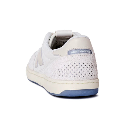 White sneaker with blue sole on a white background