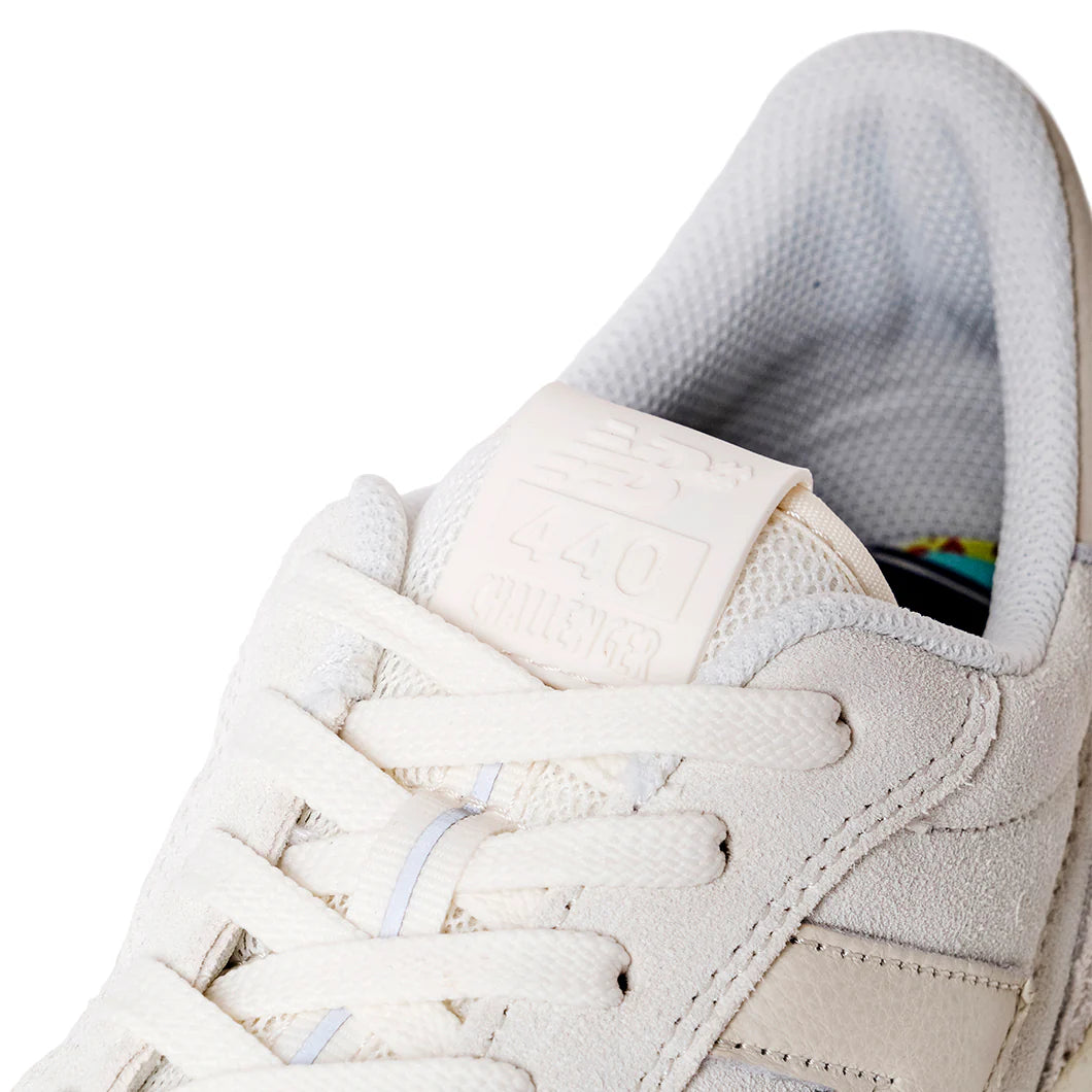 Close-up of a beige sneaker with white laces on a white background