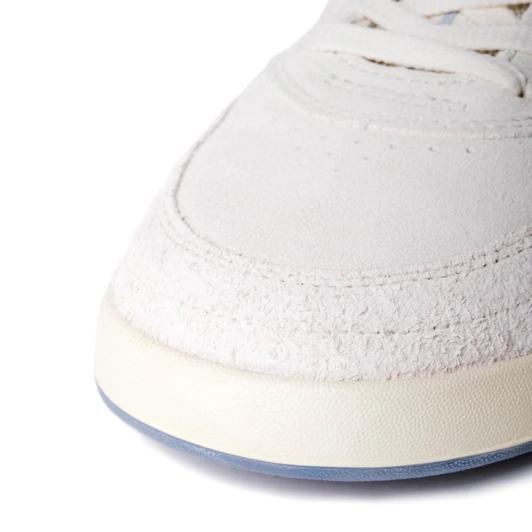 Close-up of a white sneaker with a light blue sole on a white background