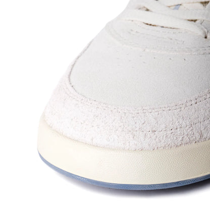 Close-up of a white sneaker with a light blue sole on a white background
