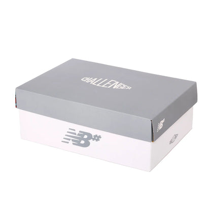 Gray and white shoe box with 'Challenger' text and New Balance logo on a white background