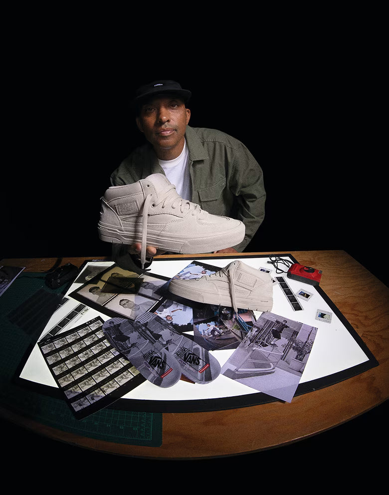Man holding a sneaker with various items on a table