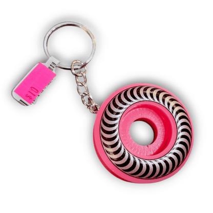 Keychain with pink and swirl patterned design on a white background