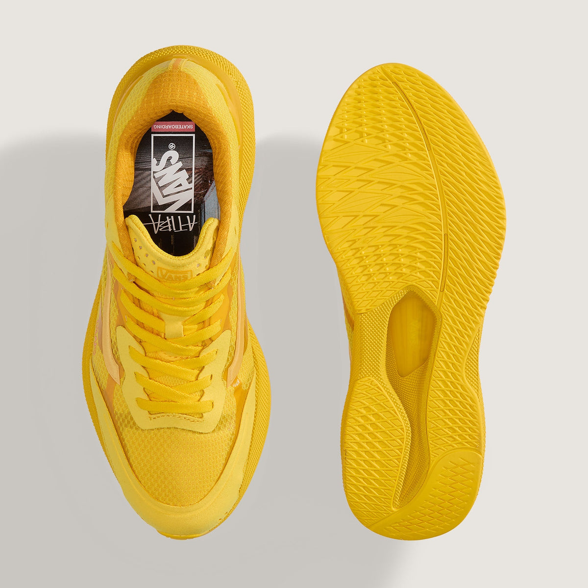 A pair of bright yellow athletic sneakers shown from a top-down view on a light gray background, displaying the side profile, front lace area, and outsole.