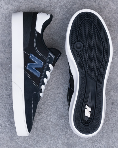 Navy blue sneakers with white soles on a gray background