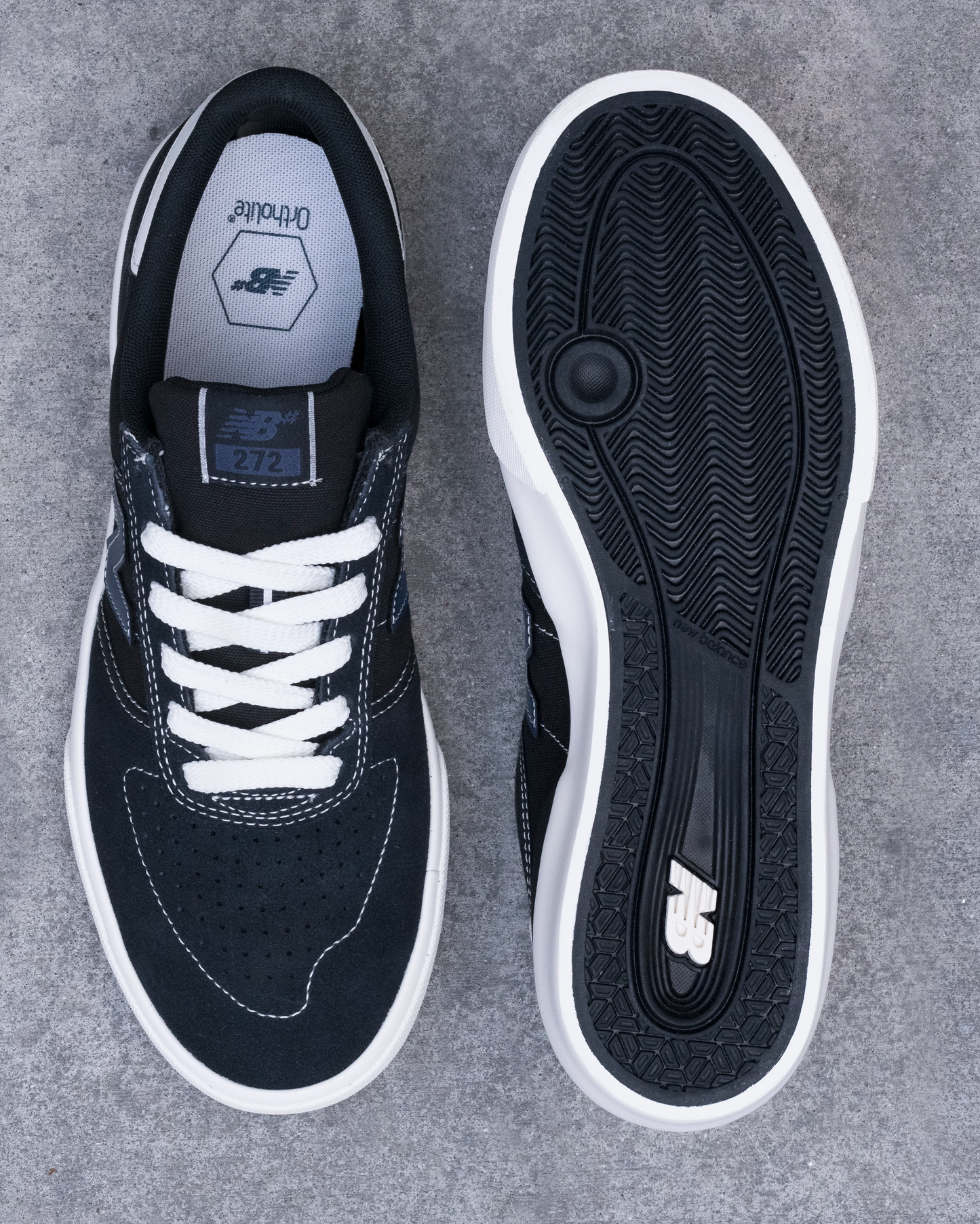 Black sneaker with white laces on a gray background