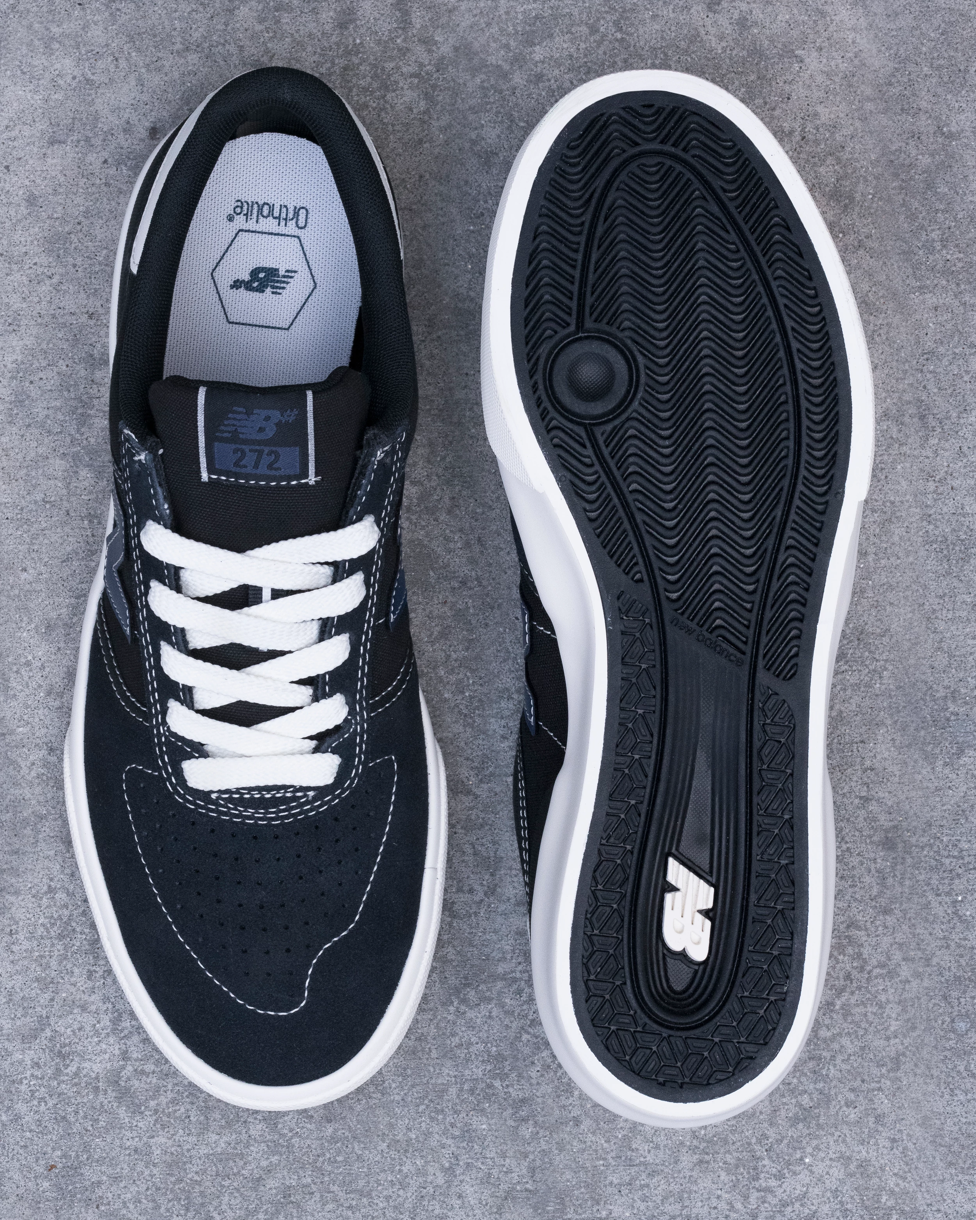 Black sneaker with white laces on a gray background