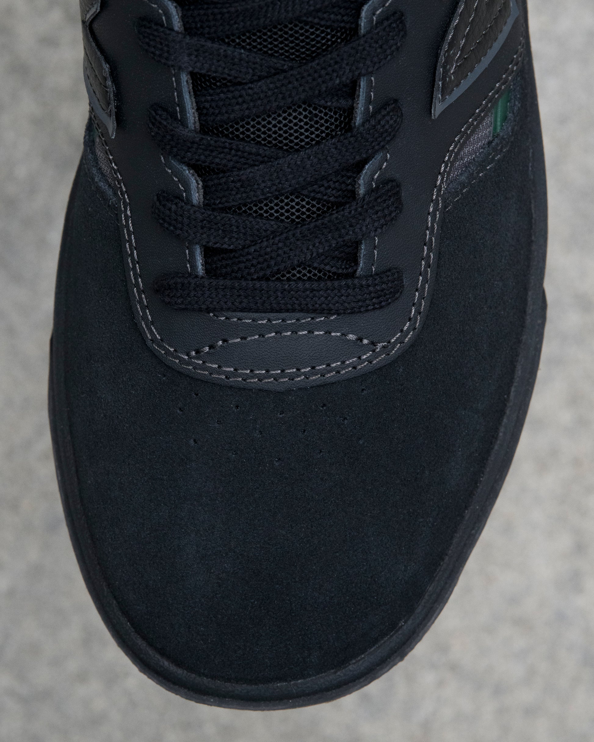 Close-up of a black sneaker on a gray concrete surface