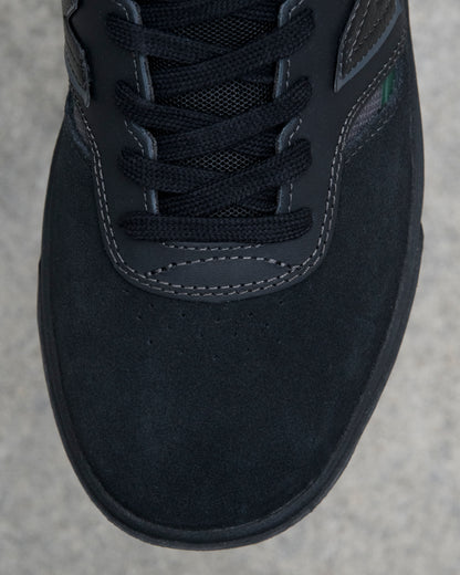 Close-up of a black sneaker on a gray concrete surface