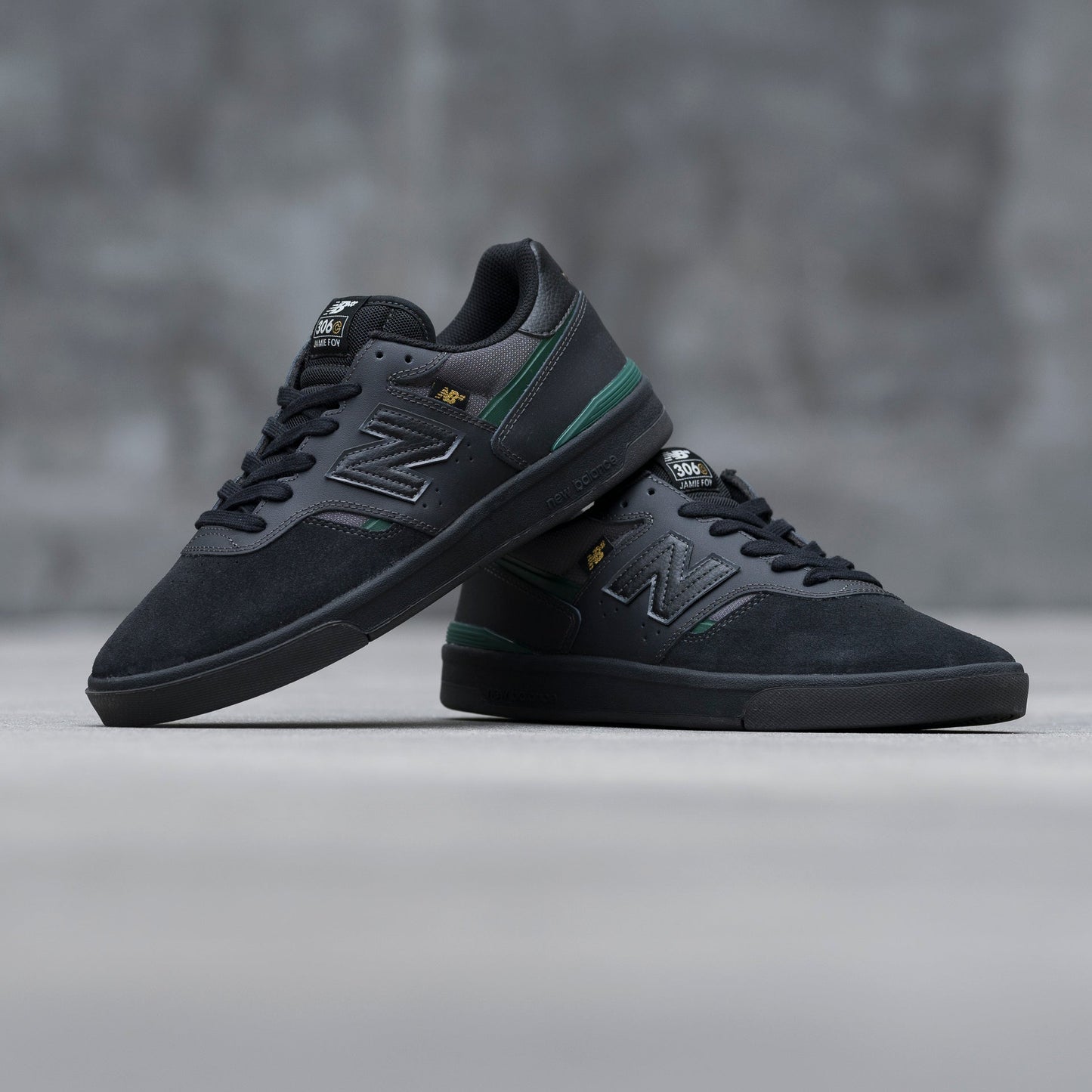Black sneakers with green accents on a gray background