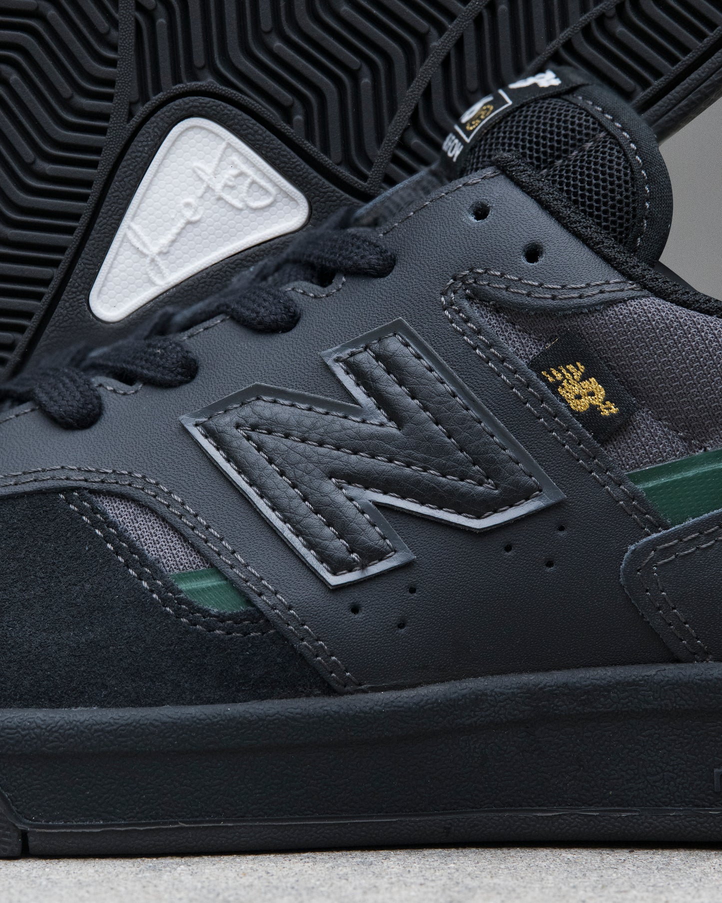 Close-up of a dark gray sneaker with New Balance logo and brand emblem.