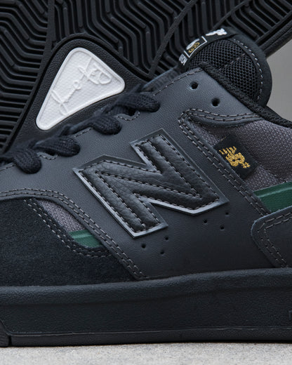 Close-up of a dark gray sneaker with New Balance logo and brand emblem.