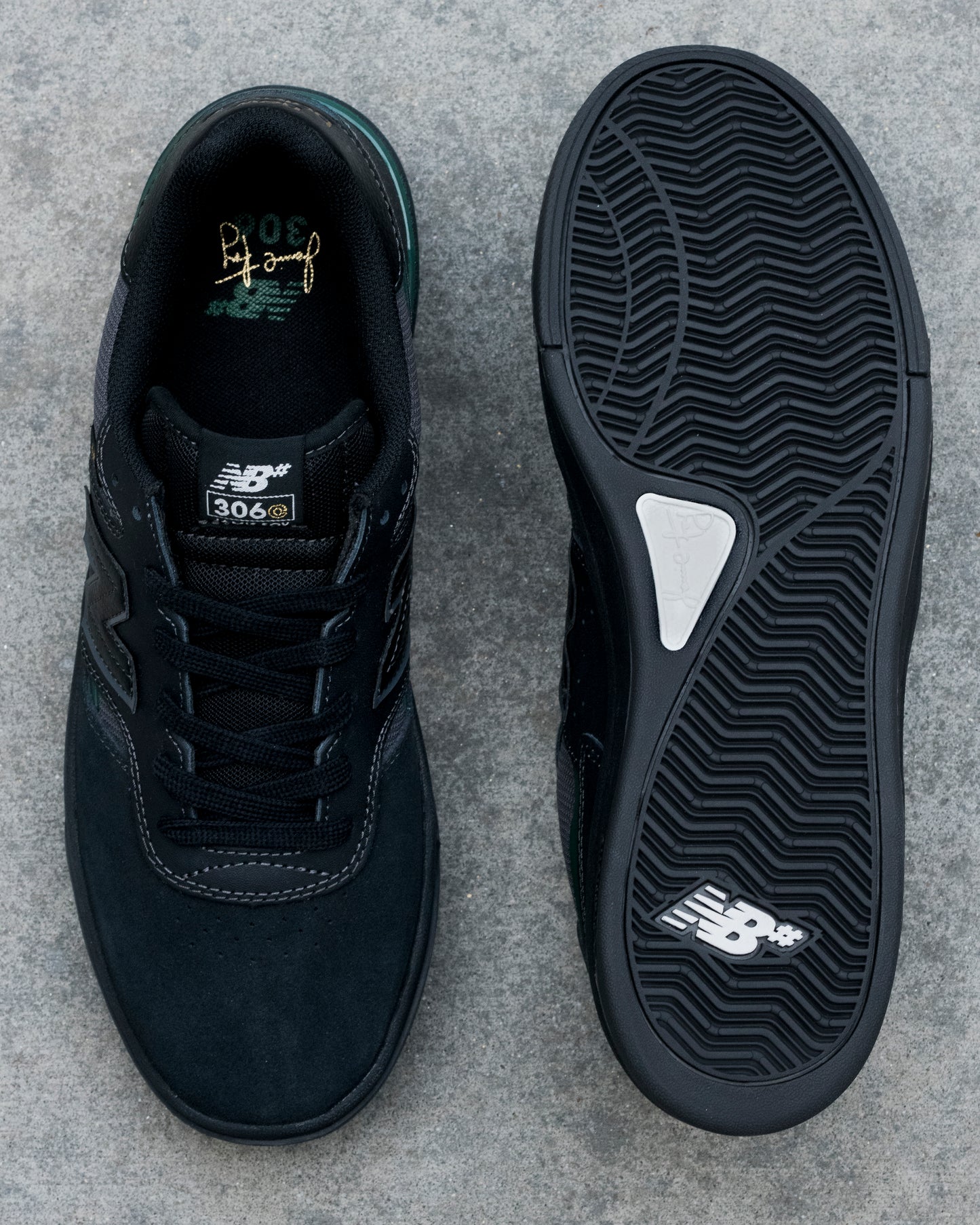 Black New Balance sneaker shown from top and bottom on a gray concrete surface