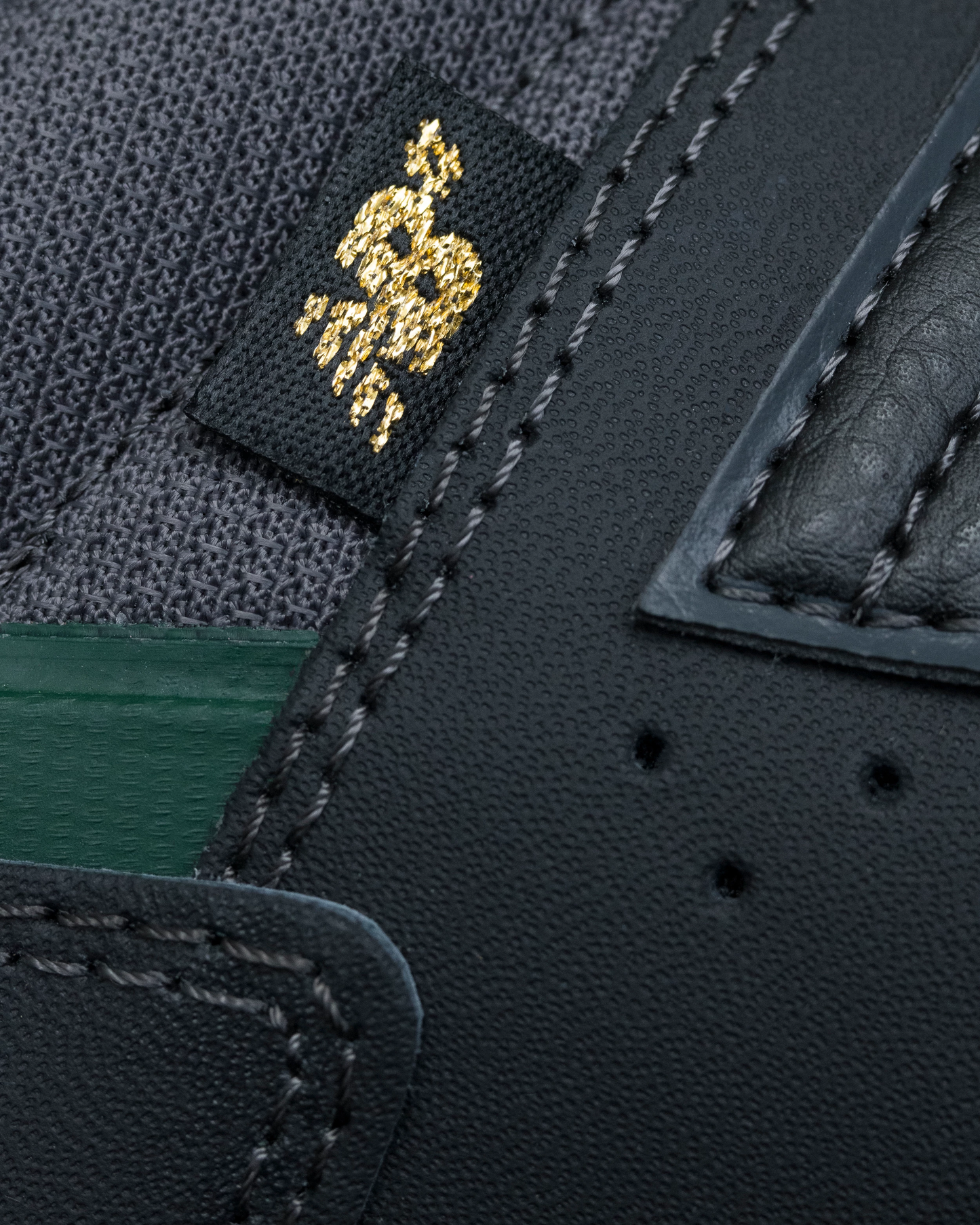 Close-up of a textured fabric with a brand logo and stitching details.