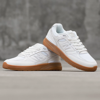 White sneakers with brown soles on a gray surface