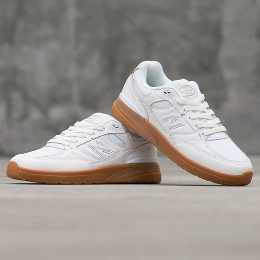 White sneakers with brown soles on a gray surface