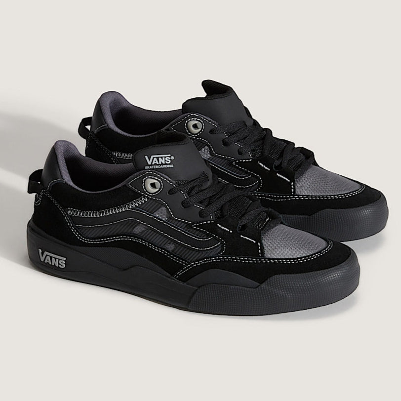 Black and gray sneakers with Vans branding on a light gray background