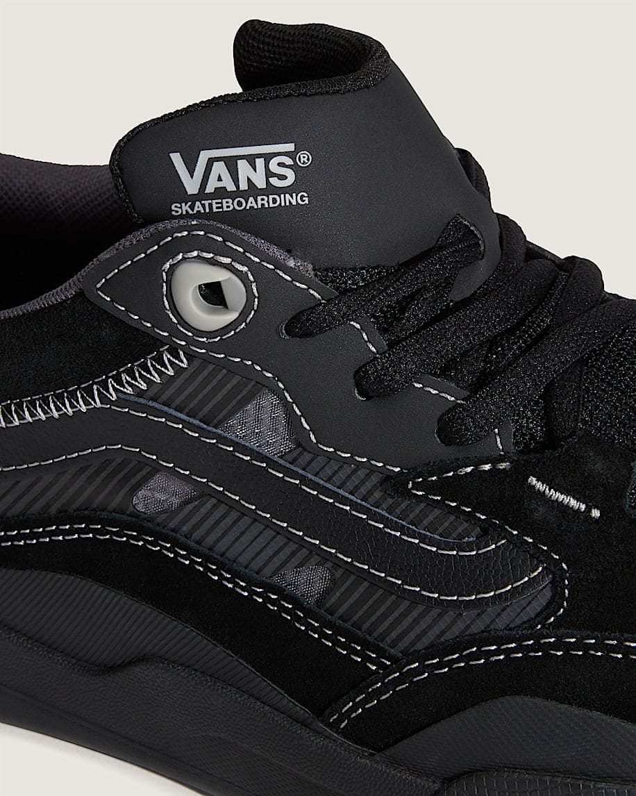 Black Vans skateboarding shoe with brand logo on a light gray background