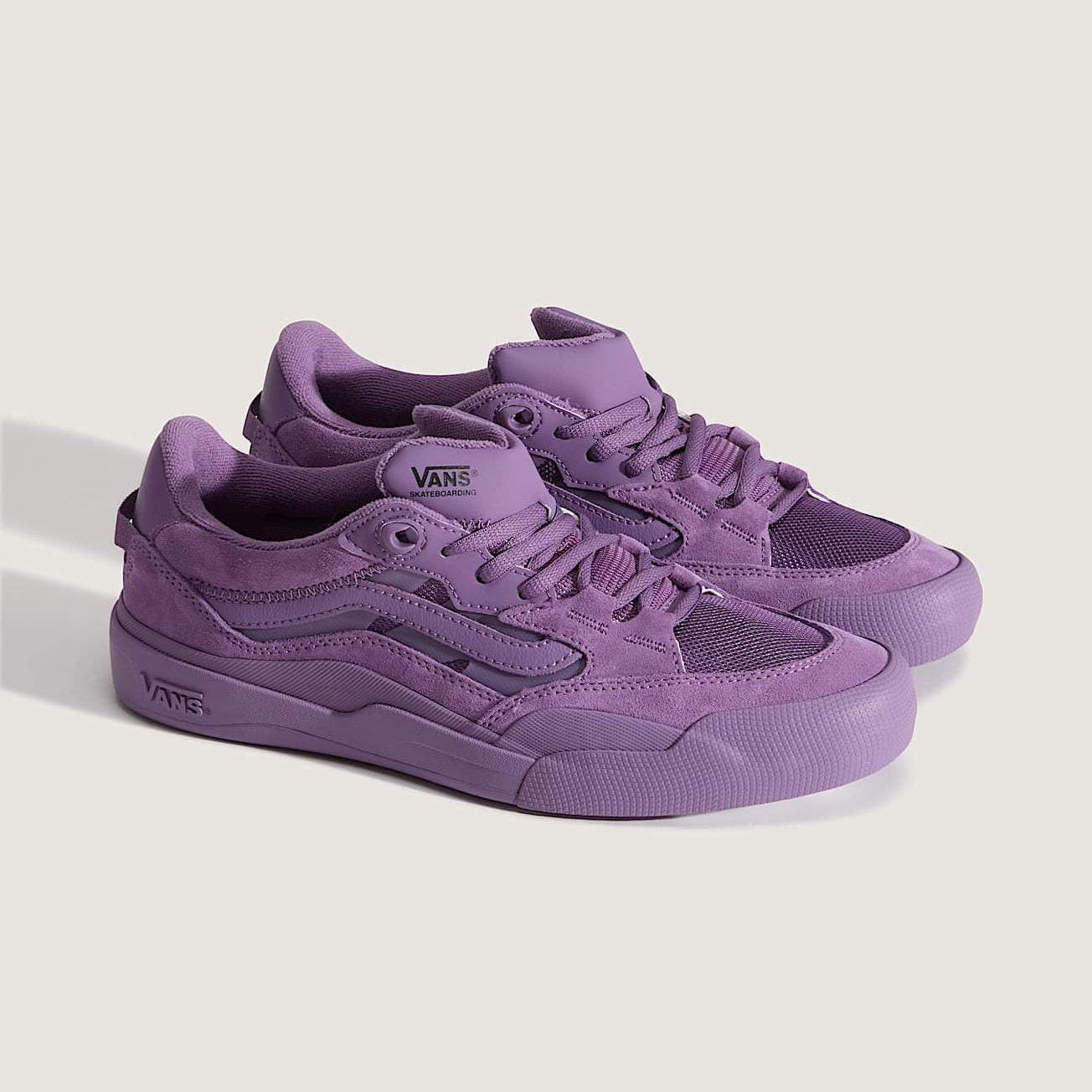 Purple sneakers with Vans logo on a light gray background