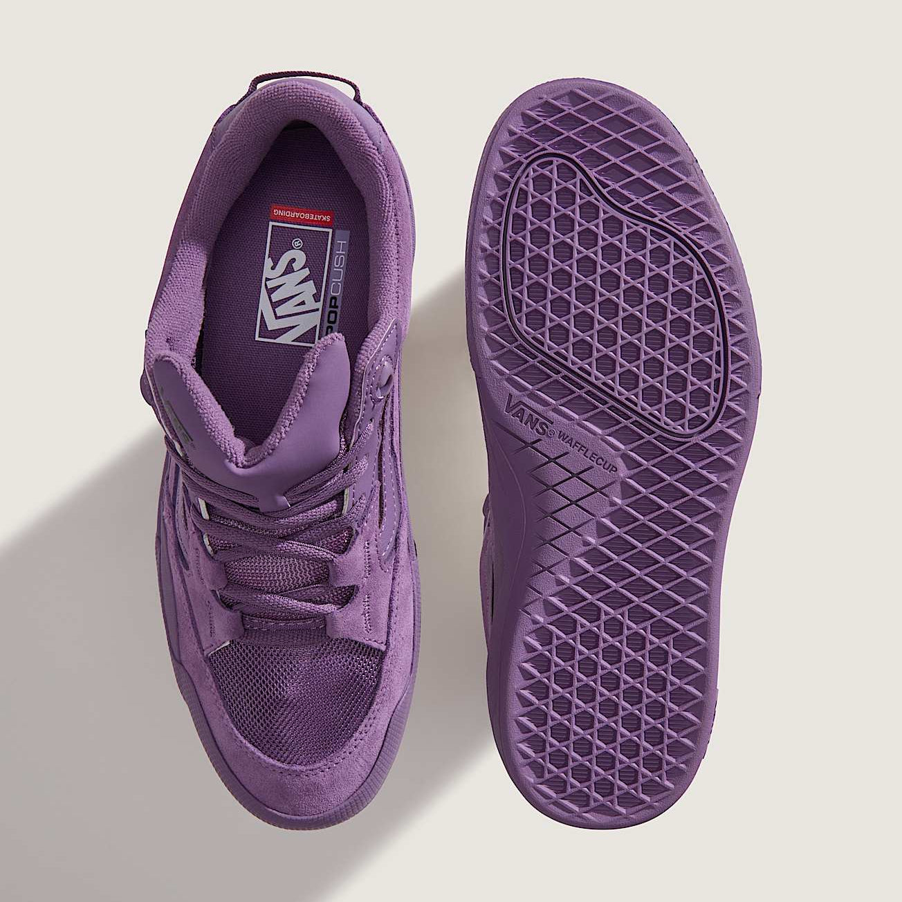 Purple sneaker with sole showing on a light gray background