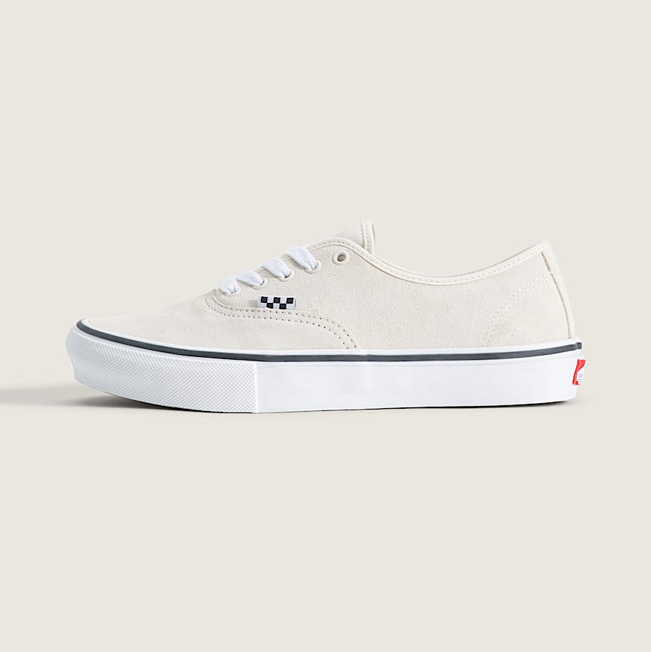 A classic low-top canvas sneaker in off-white, featuring white laces, a black and white checkered logo on the side, and a white rubber sole with a thin black stripe.
