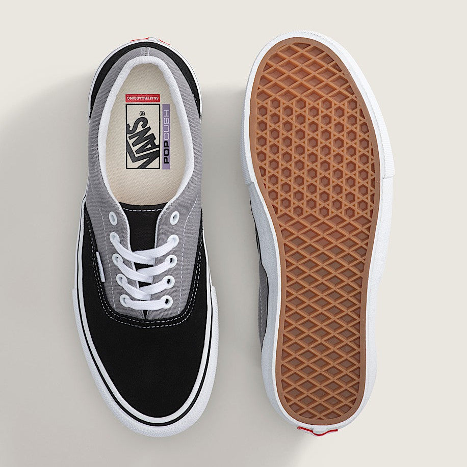 Black and gray Vans sneaker with a focus on the sole on a light background