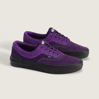 A pair of purple suede low-top sneakers with black rubber soles, displayed on a light beige background.