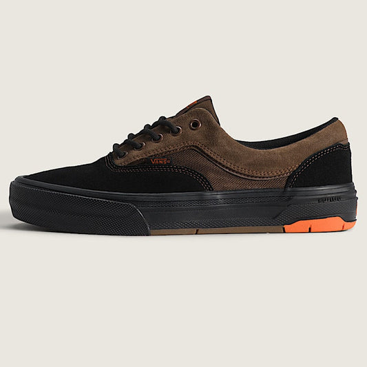 Brown and black sneaker with orange sole on a light gray background