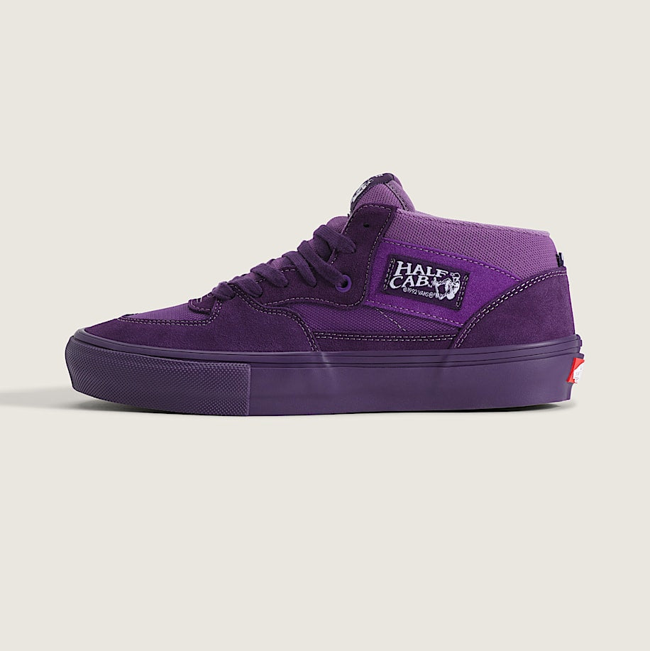 A purple suede and canvas mid-top skate shoe by Halfords, shown in profile against a light beige background.
