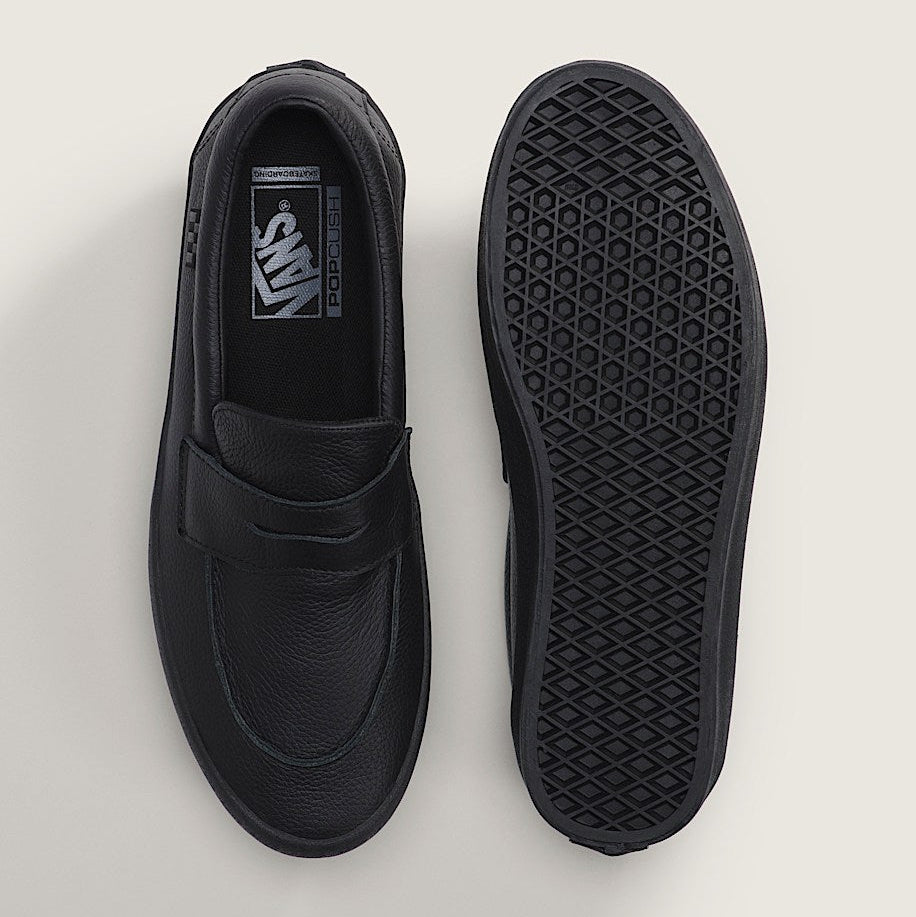Black loafer shoe with sole showing pattern on a light gray background