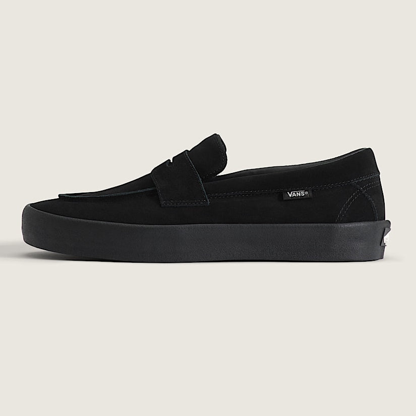 Black loafer shoe on a light beige background