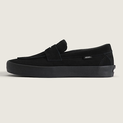 Black loafer shoe on a light beige background
