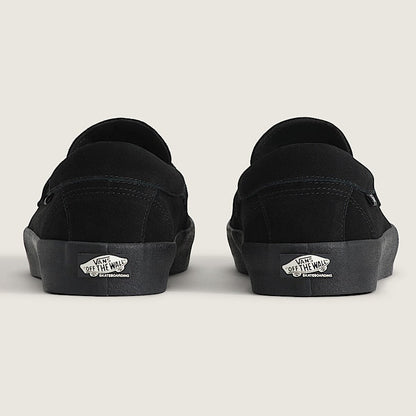 Black slip-on shoes with visible brand logo on a light gray background