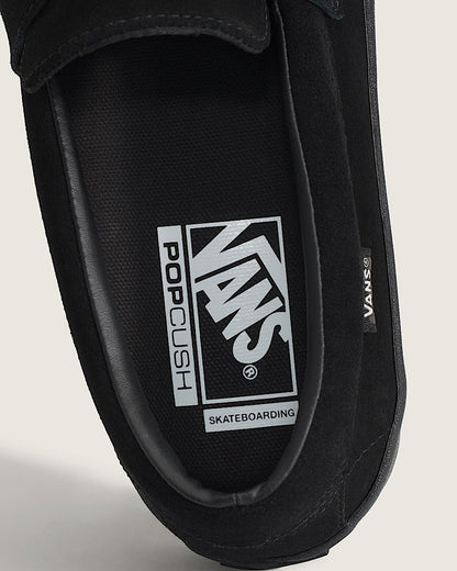 Black slip-on shoe with Vans logo on a light gray background