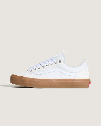 White sneaker with a brown sole on a light beige background