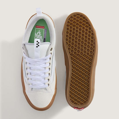 White sneaker with brown sole on a light gray background