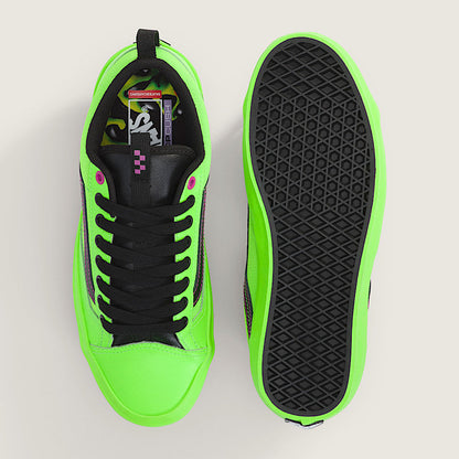 Green and black sneaker with sole showing on a light gray background