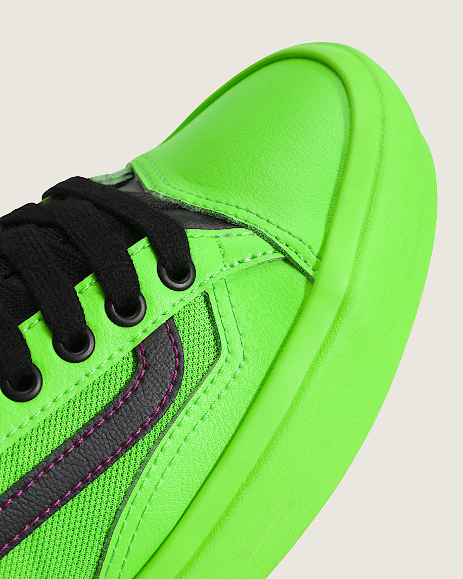 Neon green sneaker with black laces on a light gray background