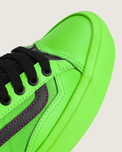 Neon green sneaker with black laces on a light gray background