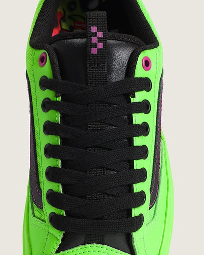 Green sneaker with black laces on a light gray background