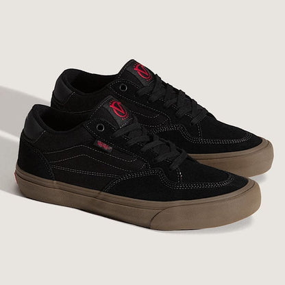 Black sneakers with red accents on a light gray background