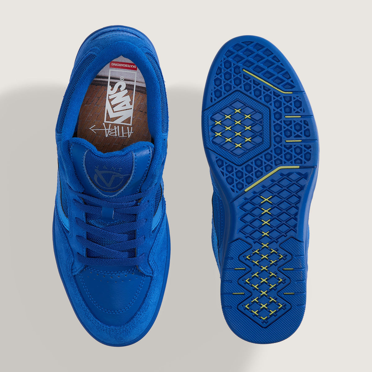 A pair of bright blue Vans sneakers shown from a top-down view, displaying the side profile of one shoe and the textured outsole of the other on a light gray background.