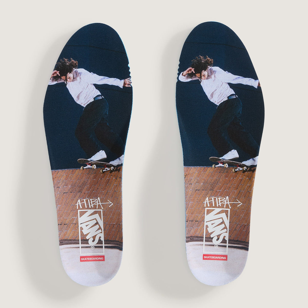 A pair of custom-printed skateboarding insoles shown flat against a light gray background. The insoles feature a graphic of a skateboarder in a white shirt and black pants on a dark navy blue upper section, transitioning into a brown wood-grain section with white and red Supreme branding.