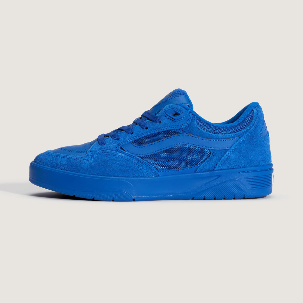 A single low-top sneaker in a vibrant royal blue suede and mesh material, shown from a side profile against a light beige background.