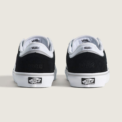 Black and white Vans sneakers on a light beige background