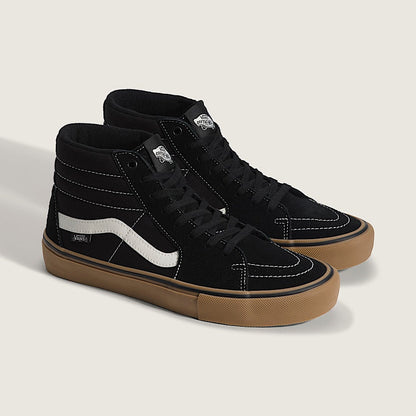 Black high-top sneakers with white stripes and brown soles on a light gray background