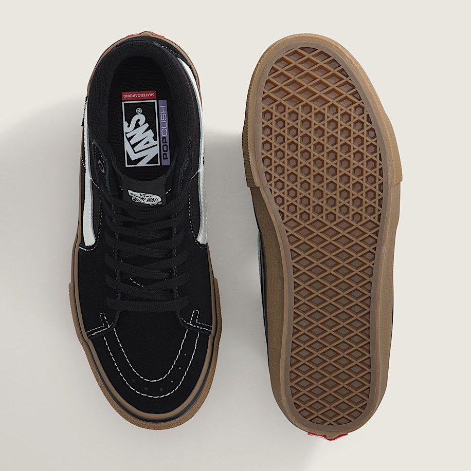 Black sneaker with brown sole on a white background
