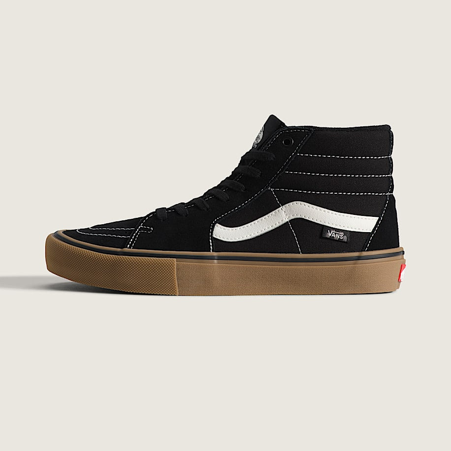 A single black Vans high-top sneaker with a white side stripe, black laces, and a brown gum sole, shown in profile against a light beige background.