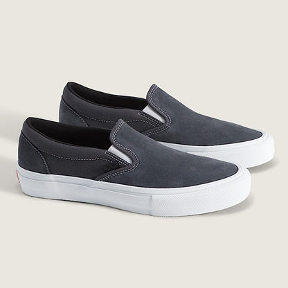 A pair of slip-on platform sneakers in dark gray suede with thick white platform soles, shown on a light beige background.