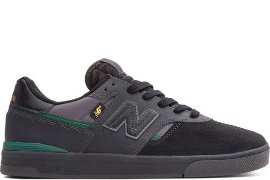 Black and gray sneaker with green accents on a white background